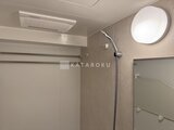 プラウドフラット西蒲田 浴室暖房乾燥機と丸型照明が備わった落ち着いた浴室空間
