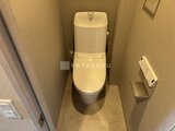 プラウドフラット西蒲田 温かみのあるトイレ空間に設置された一体型の清潔なトイレ