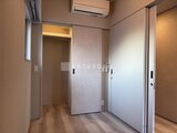 プラウドフラット西蒲田 落ち着いた色合いの洋室、大きなクローゼットと採光窓のある空間