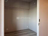 プラウドフラット西蒲田 床暖房対応のフローリングと壁面収納を備えた落ち着いた洋室