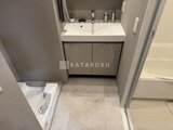 プラウドフラット西蒲田 白い洗面ボウルと収納付きの洗面台が備わった洗面室