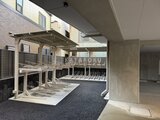 アリビス五反野 自転車駐輪場から見た建物の共用部分と屋根付き駐輪スペース