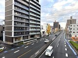 アリビス五反野 前面道路から見た建物外観と周辺の街並み