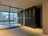 アリビス五反野 大きなガラス扉と黒いエレベーターが設置された明るいエントラン