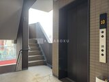 アリビス五反野 エレベーターホール奥に階段へと続く、落ち着いた色調の共用部廊
