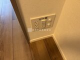 アリビス五反野 壁に設置されたコンセント・スイッチと木質フローリングの様子