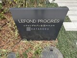 ルフォンプログレ赤羽マークス 物件名の看板と周囲の緑が配置された共用部の入口
