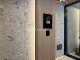 ルフォンプログレ赤羽マークス エレベーター内の壁面にコンクリート調タイルと木目パネルを組み