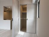 ルフォンプログレ赤羽マークス 引き戸を開けた広めのクローゼット、左奥に見えるキッチン