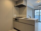 ルフォンプログレ赤羽マークス モダンなデザインのキッチンとコンロ、レンジフードが備わった調