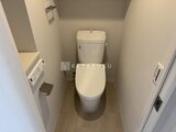 ルフォンプログレ赤羽マークス 温白色の壁と木目調床が落ち着いた印象のトイレ空間