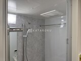 ルフォンプログレ赤羽マークス グレー調の壁にシャワーを備えたモダンなバスルーム