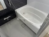 ルフォンプログレ赤羽マークス 白い浴槽と黒いアクセントパネルを備えたモダンな浴室