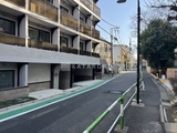ロスアルコス千駄木 前面道路から見たモダンな建物外観と駐車場入口