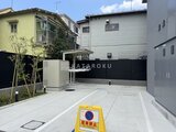シーズンフラッツ大森北三丁目 駐車場から見た建物と黒いフェンスに囲まれた敷地の様子