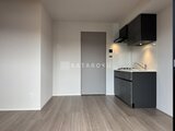 シーズンフラッツ大森北三丁目 モダンな黒いキッチンと開放的なリビングダイニング空間