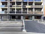 シーズンフラッツ大森西 駐車場から見たモダンな外観と1階商業施設入口の様子