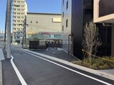 シーズンフラッツ大森西 駐車スペースと周辺建物が見える物件前のアプローチ