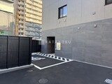 シーズンフラッツ大森西 駐車場から見た建物エントランスと落ち着いた印象の外壁