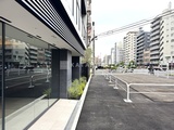 シーズンフラッツ大森西 開放的なエントランスから見た駐車場と周辺住宅街の様子