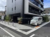 コンフォリア・リヴ大崎 モダンな外観の建物とカーポート、緑を配した落ち着きのある駐車