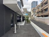 コンフォリア・リヴ大崎 モダンな外観の建物と整備されたアプローチが見える街並みの風景