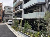 コンフォリア・リヴ大崎 緑を配した開放的なエントランスと駐車スペースの外観