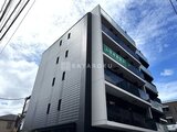 コンフォリア・リヴ大崎 空と雲を背景にした、モダンなタイル張りの建物外観