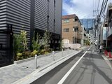 コンフォリア・リヴ大崎 明るい街路樹が植わる敷地前の道路から見た建物外観