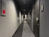 コンフォリア・リヴ大崎 落ち着いた色合いでまとめた廊下からエレベーターホール方向を見