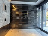 コンフォリア・リヴ大崎 木目調と石目調タイルで統一されたモダンなエントランスホール