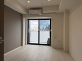 コンフォリア・リヴ大崎 明るい床材が印象的な、窓から都市景観を望むワンルーム空間