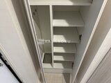 コンフォリア・リヴ大崎 複数の棚が備わったゆとりのある廊下収納の内部