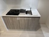 コンフォリア・リヴ大崎 ガスコンロと流し台を備えた落ち着いた色調のキッチンカウンター