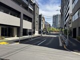 グランジット月島TOKYO BAY 現代的な建物に囲まれた明るい印象の街路から見た建物外観