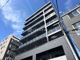 グランジット月島TOKYO BAY 青空を背景に見上げた、白とグレーの洗練された建物外観