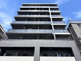 グランジット月島TOKYO BAY 青空を背景にした、モダンなバルコニー付きの建物外観