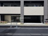 グランジット月島TOKYO BAY 前面道路から見たモダンな建物外観と車庫入口