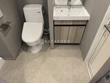 グランジット月島TOKYO BAY 温水洗浄便座付きトイレと洗面台が配置された落ち着いたトイレ空