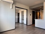 グランジット月島TOKYO BAY 明るい床色のリビングダイニングと、奥に見えるベッドルームへの