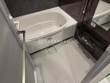 グランジット月島TOKYO BAY 白いバスタブと暗色タイルの落ち着いた浴室空間