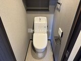 グランジット月島TOKYO BAY 落ち着いた色合いの壁紙が張られた温水洗浄便座付きトイレ