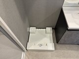 グランジット月島TOKYO BAY 白基調の洗浄便座付きトイレと手洗いスペースの様子