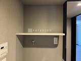 グランジット月島TOKYO BAY 洗面スペースに設置された手洗いシンクと収納棚のある壁面