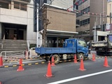 コンフォリア・リヴ門前仲町イースト 建物前の通りに停められた青いトラックと周囲の都市風景