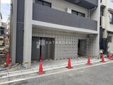 ジーグランデ西日暮里 深めグレーのタイル張りで統一された建物の駐車場入口