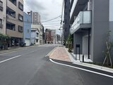 ドゥーエ三ノ輪3 前面道路から見たモダンな建物エントランス周辺の街並み