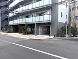 ドゥーエ三ノ輪3 前面道路から見たモダンな建物の1階エントランスと駐車場
