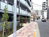 ドゥーエ三ノ輪3 前面道路から見たモダンな建物外観と植栽が調和したエントランス