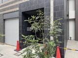 ACPレジデンス中野新橋 モダンなタイル張りのエントランス前に植栽が配置された外観
